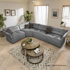 a blue sectional couch sitting on top of a wooden floor next to a coffee table