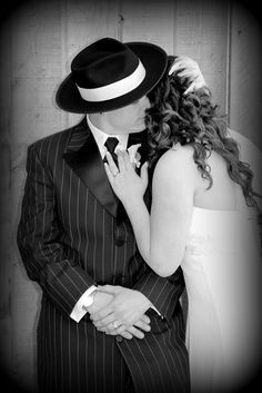 a man in a suit and tie kissing a woman with her hand on her chest