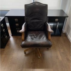 an office chair sitting on top of a hard wood floor next to a black desk