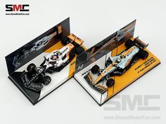 two model race cars are shown in their packaging boxes, one is white and the other is orange