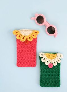 two crocheted items are laying next to each other on a blue surface with sunglasses