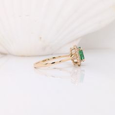 This beautiful dainty ring features a Zambian emerald in solid 14k yellow gold. A classic ring design perfect for daily wear, work or engagement. Classic Yellow Gold Emerald Ring With Halo, 14k Gold Emerald Ring With Halo Design, Emerald Halo Ring In Yellow Gold, Formal 14k Gold Emerald Ring With Halo, 14k Gold Birthstone Ring With Emerald Cut Halo Setting, 14k Gold Emerald Ring With Halo Design For Promise, Elegant 14k Gold Emerald Ring With Halo Design, Yellow Gold Emerald Halo Ring For May Birthstone, Emerald Birthstone Ring In Yellow Gold With Halo Setting