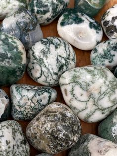 some green and white rocks on a wooden surface