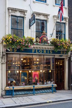 a store front with flowers on the windows