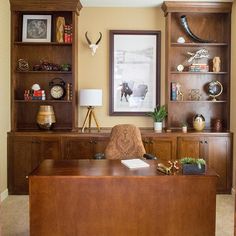 a wooden desk sitting in front of a book shelf