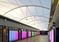 the inside of a building with many windows and colorful screens on it's walls