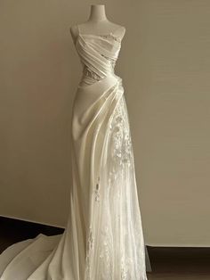 a white wedding dress on display in front of a wall with an image of the back of it