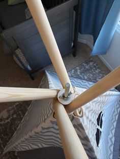 an overhead view of a wooden ceiling fan in a room with carpet and blue curtains