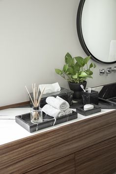 a bathroom counter with towels, soaps and plants on it