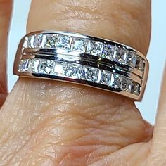 a woman's hand with a wedding ring on top of her finger and the band is