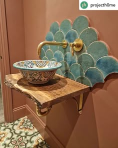 a bathroom sink sitting on top of a wooden counter next to a wall mounted faucet