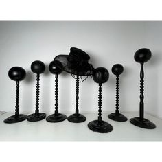 eight black candlesticks with hats on them