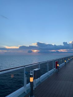 the deck of a cruise ship at dusk with candles lit up in front of it