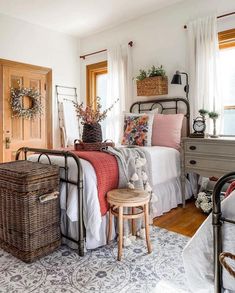 a bed room with a neatly made bed and baskets on the nightstands next to it