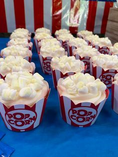 cupcakes with white frosting and candy on them are lined up in rows