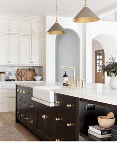 the instagram page shows an image of a kitchen with white cabinets and gold accents