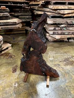 a piece of wood sitting on top of a wooden table next to stacks of lumber