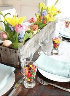 a wooden box filled with lots of candy sitting on top of a dining room table