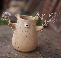 a ceramic bear vase with flowers in it's mouth