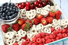 a tray filled with fruit and pretzels on top of a table