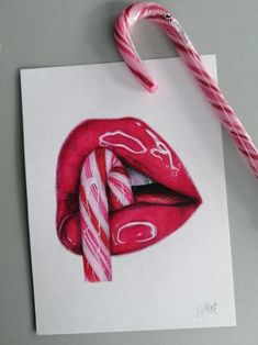 a candy cane is next to a drawing of a woman's lips and tongue