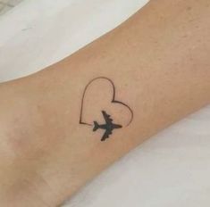 a small tattoo on the foot of a person with an airplane flying in front of them