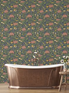 a bath tub sitting on top of a wooden floor next to a wallpaper covered in flowers