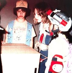 three young people standing around a box that is open and has the number six on it