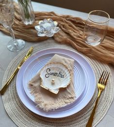 the place setting is ready to be served at this beach themed wedding reception in white and gold