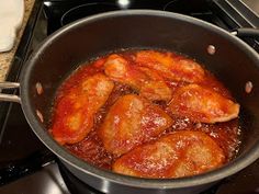 a pan filled with meat sitting on top of a stove