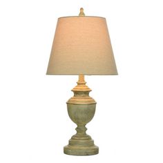 a table lamp with a beige shade on it's base and a white background