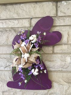 purple and white flowers are placed on the side of a brick wall