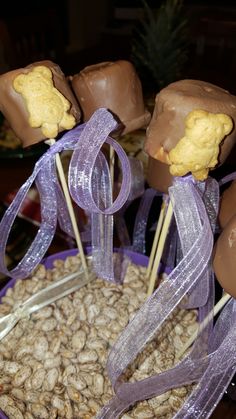 there are chocolate candies and candy on the stick in the purple bowl with ribbon