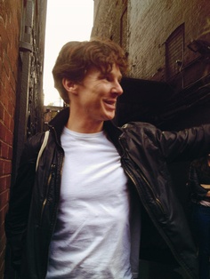 a young man standing in an alley laughing