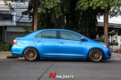 a blue car is parked on the street