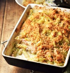 a casserole dish filled with pasta and meat covered in grated crumbs