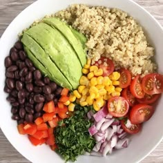 a bowl filled with rice, beans, avocado, tomatoes and other vegetables