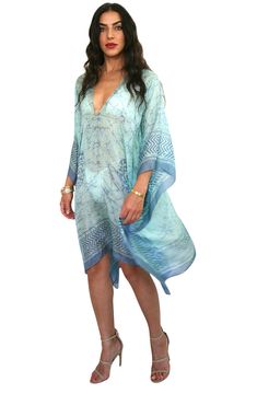 Our "Mid Length V-Neck Kaftan" in our beautiful Silk Tabi quality is an easy but elegant kaftan to throw on and go. This AQUA has an extremely airy feel & the Aqua color is truly stunning. The tunic has a Simple V neck front and back neckline. Great over swimwear or worn over a slip dress. The kaftan is a One Size fits all and can accommodate XS-2XL. Fabrication Content: 100% Tabi Silk Print Process: 100% hand made batik print, and every item is made by hand and a one of a kind item & limited items will be made in this style, Soft pink base with soft plum print. Size run: One Size Made in: Garment is custom made in LA - allow for 3 days in making plus transit time Care: Dry Clean Or rinse by hand in Luke warm water with small amount of detergent in the sink. The fabric is delicate so rise Flowy V-neck Tunic For Beach Cover-up, Green V-neck Free Size Kimono, Blue V-neck Kaftan For Beach Season, Flowy V-neck Kaftan For Beach Cover-up, Elegant V-neck Kimono For Beach Cover-up, Flowy V-neck Breezy Cover-up, Elegant V-neck Kimono For Vacation, Elegant Free Size Kaftan For Beach Cover-up, Elegant V-neck Kimono Beach Cover-up