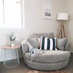 a living room with a chair, table and rugs on the floor in front of a window