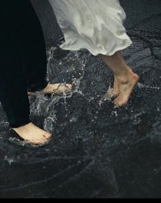 two people are walking in the rain with their bare feet sticking out from under water