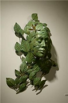 there is a mask made out of leaves on the wall