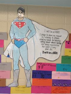 a bulletin board with a drawing of a man in a superman costume and words written on it