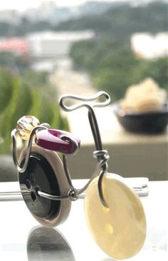 a pair of earrings sitting on top of a table next to a window sill