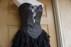 "Vintage size small black dress with leather sweetheart bodice and ruffle lace layered skirt. Zips up the back. In good vintage condition but the puller on the zipper need to be reconnected somehow - see last photo. Measurements taken across front laid flat 16\" across front armpit to armpit 12.5\" across front of waist -doubles to 25\" 19\" across front of hips 26\" length armpit to bottom" Black Fitted Corset Dress With Ruffles, Black Corset With Lace Bodice And Fitted Bodice, Lace Fitted Corset For Alternative Fashion, Fitted Lace Corset For Alternative Fashion, Steampunk Corset Dress For Party With Fitted Bodice, Black Ruffled Corset With Fitted Bodice, Black Ruffled Fitted Bodice Corset, Black Corset With Lace Trim And Fitted Bodice, Fitted Black Corset Dress With Lace Bodice