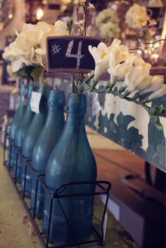 four blue vases with flowers in them are for sale