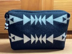 This cute cosmetic bag is handcrafted from quality Pendleton® coat weight wool.  It is just the right size for a cosmetics, medications, gadget / device  cords, jewelry, or whatever!   Dimensions:  Height:  6 inches Width:  10 inches  Gusseted Base:  2 1/2 inch  It stands by itself.  The front and back are the same. This bag is unlined because the inside is pretty too, and all seams are finished. It has a heavy duty purse zipper and coordinating Leather  zipper pull with glass crow beads for extra detail. More Night Owl Market Cosmetic Bags:  https://www.etsy.com/shop/NightOwlMarket?section_id=6814373 Home Page:  http://www.etsy.com/shop/NightOwlMarket Pendleton Coat, Pendleton Woolen Mills, Bag Makeup, Zippered Pouch, Night Owl, Toiletry Storage, Leather Zipper, Cosmetic Bags, Zipper Pouch