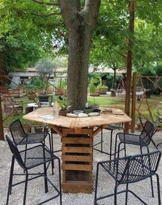 an outdoor table and chairs under a tree