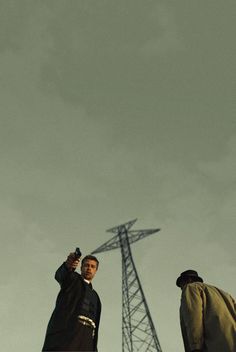 two men standing next to each other in front of a radio tower