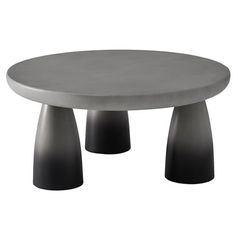 a round table with three black bases on it's legs and an oval top