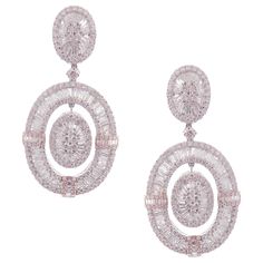 These modern oval baguette earrings are crafted in 18-karat white gold, weighing approximately 14.65 total carats of SI-V Quality white diamond. French Clip backing. Beautiful rose gold accent. Our Ballroom Collection feature earrings for those with bold/classy aesthetics and elegant tastes. 346 Round Diamonds = 7.84 ct 235 Baguette Diamonds = 6.81 ct Baguette Earrings, Baguette Earring, French Clip, Rose Gold Accents, Diamond Dangle Earrings, American Modern, Circle Diamond, White Gold Earrings, Women Diamond